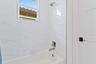 Bathroom with tub and marble tile surround