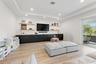 Recreation room with built-in media console, mounted TV, and floating shelves