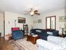 Living room featuring crown molding, ceiling fan, wood finished floors, and a wall mounted air conditioner