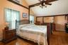 Bedroom with vaulted ceilings and beams, ceiling fan, lofted ceiling, light hardwood , and a wall mounted AC