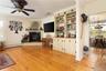 Living room with light hardwood, built ins, ornamental molding, and a propane fireplace