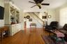 Living room featuring hardwood flooring, crown molding, and ceiling fan