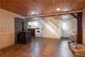 Laminate flooring. mini kitchen, wood ceiling, beam ceiling, and a pellet stove