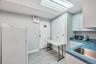 Functional kitchen area featuring a stainless steel sink, light cabinetry, and light wood-finish flooring