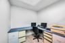Corner workspace with a light blue speckled countertop, recessed ceiling lighting, and wood-finish flooring