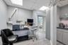 Office space featuring wood-finish flooring, drop ceiling with integrated lighting, and light gray wall paint