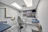 Dedicated clinical space featuring wood-finish flooring, light gray wall paint, and a dropped ceiling with integrated fluorescent lighting