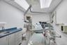 Medical treatment room featuring light gray walls and recessed fluorescent lighting
