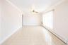 Spacious room featuring geometric pattern tile flooring, crown molding, and a ceiling fan with integrated lighting