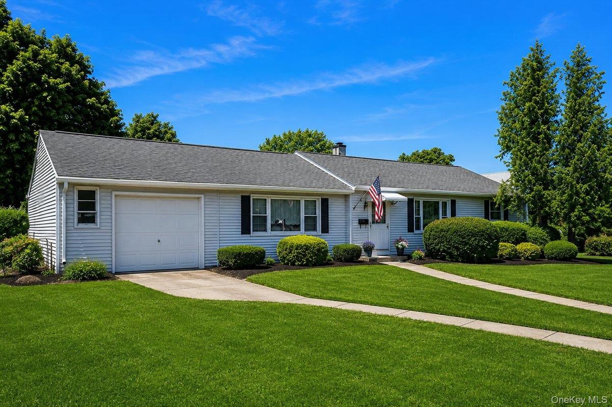 Ranch-style residence featuring light-colored siding and a dark shingle roof