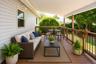 Covered deck featuring wood-finish flooring, wood railings with black balusters, and a white paneled ceiling