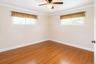 Room featuring wood-finish flooring, white baseboards, and white crown molding