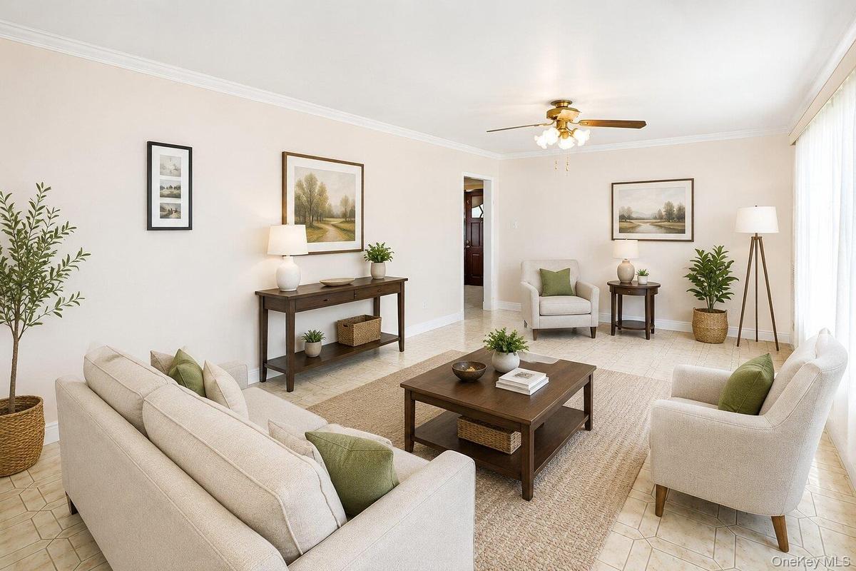 VIRTUALLY STAGED. Spacious living area featuring light-toned walls, crown molding, and tiled flooring