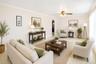 VIRTUALLY STAGED. Spacious living area featuring light-toned walls, crown molding, and tiled flooring