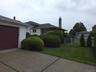 Detached 2 car garage featuring white horizontal siding, a dark red garage door, and a coordinating dark red side door