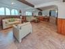 Spacious living area featuring large format tile flooring and wood paneling