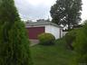 Detached 2 car garage featuring white horizontal siding, a dark red garage door, and a coordinating dark red side door
