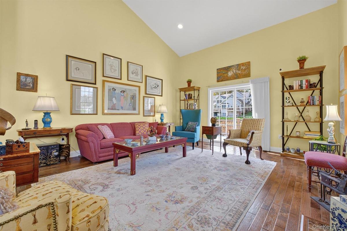 Living room with high vaulted ceiling, dark wood-style floors, and recessed lighting
