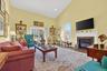 Living room with high vaulted ceiling, a high end fireplace, plenty of natural light, wood finished floors, and recessed lighting