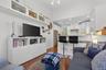 Living area with dark wood-style flooring, recessed lighting, and a high ceiling
