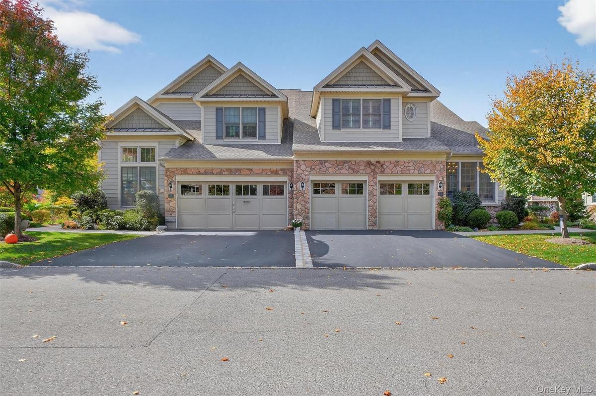 Craftsman house with stone siding, driveway, an attached garage, and a shingled roof