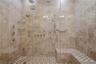 Close-up of the oversized spa-inspired shower showcasing elegant tile work and sleek modern finishes.
