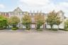 Townhome exterior featuring a dormer roofline, red brick accents.