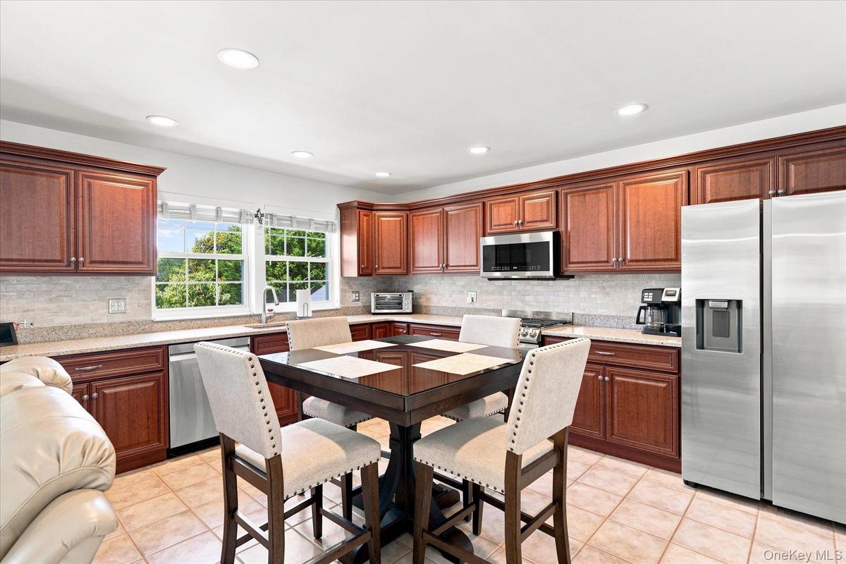 Large granite Eat In Kitchen with newer SS Appliances, cherry cabintry and open floor plan