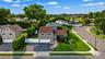Corner property Split-level residence featuring a two-car garage, established landscaping, and a curvilinear paved driveway