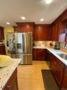 Kitchen featuring custom wood cabinetry, a stainless steel French door refrigerator, and speckled countertops