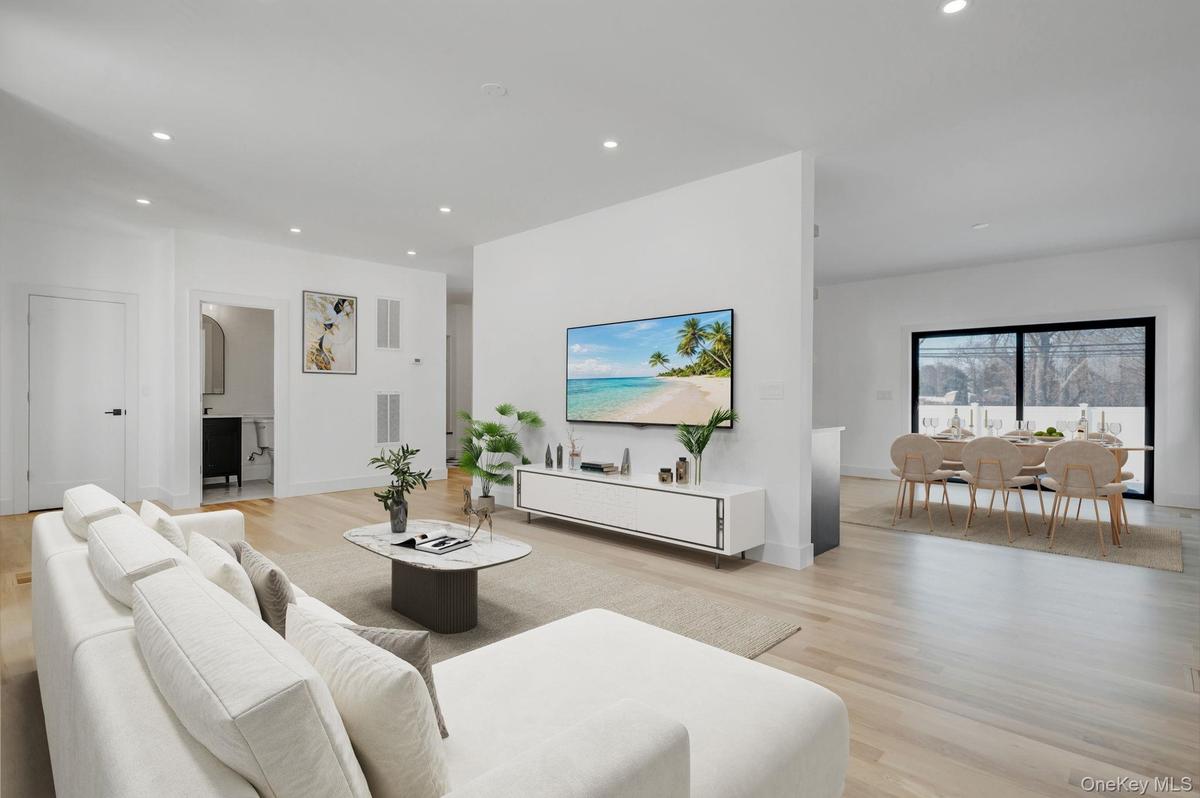 Spacious and open living area filled with natural sunlight from oversized windows, designed for both everyday comfort and entertaining.