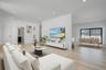 Spacious and open living area filled with natural sunlight from oversized windows, designed for both everyday comfort and entertaining.