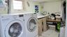 Laundry area featuring a window, built-in countertop, tile flooring, and overhead lighting