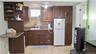 Wood-finish cabinetry, a white basin sink, and a tiled backsplash