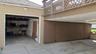 One-car garage and additional covered parking pad with a lattice-style railing overhead