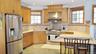 Full kitchen featuring stainless steel appliances, custom wood cabinetry, extensive countertop space, recessed lighting, and tile flooring
