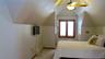 Third floor, room featuring sloped ceilings, a wood-framed window with blinds, and a ceiling fan with integrated lighting