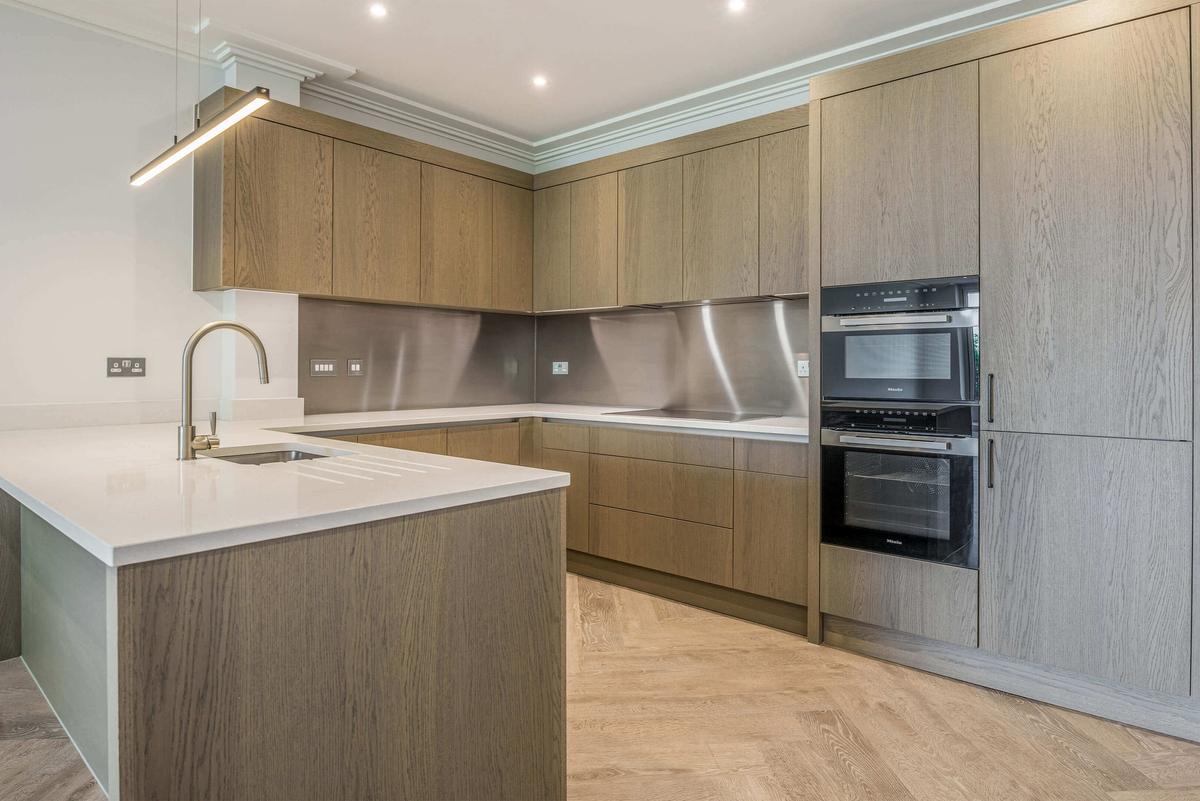 Bespoke kitchen with composite stone worktops and island in a Pavilion apartment, Sunningdale Park