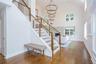 Open-concept entry foyer featuring a grand staircase with wood railings and cable balusters