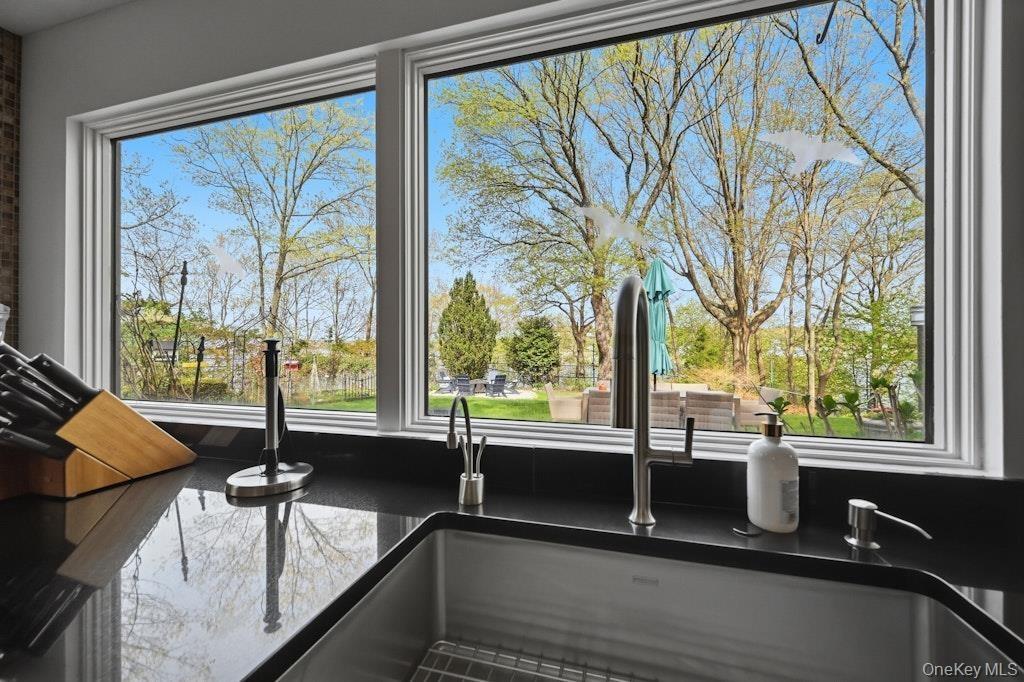 Kitchen window overlooking a landscaped exterior