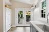 Kitchen with glass doors that lead out to expansive patio and backyard