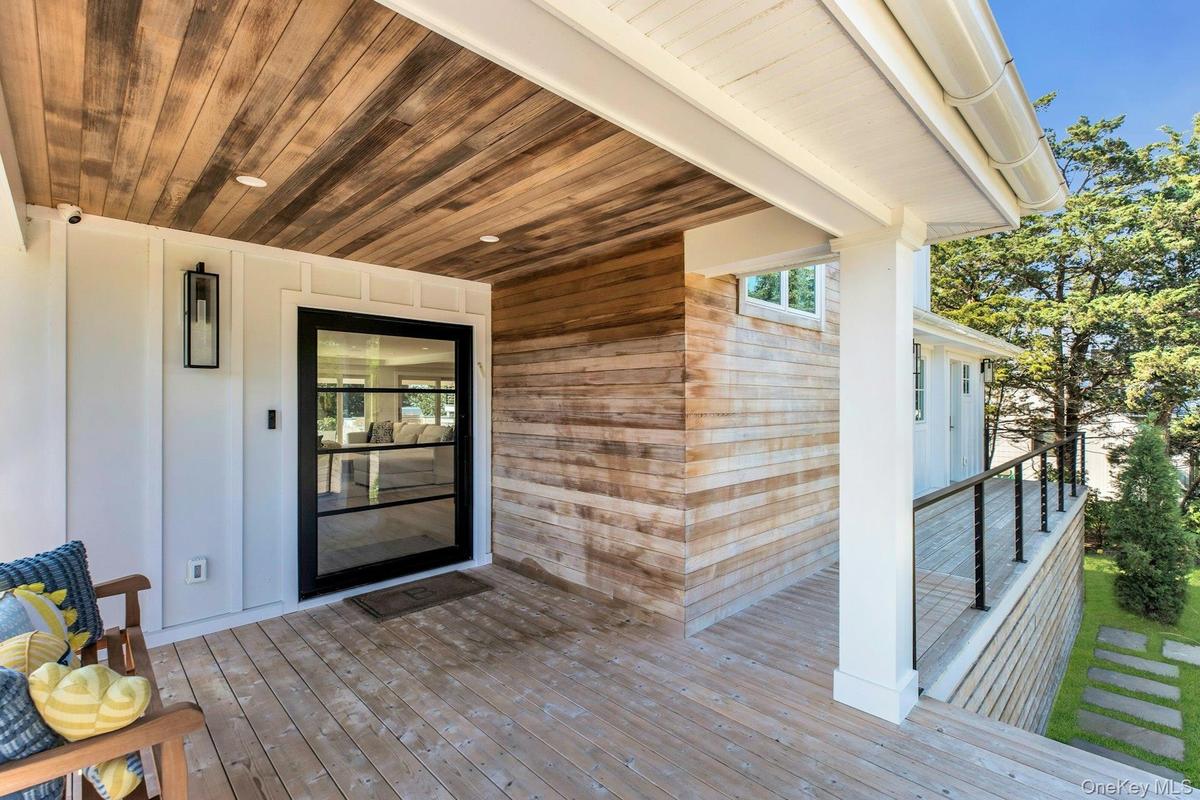 Covered porch featuring a wood-plank ceiling, wood-finish flooring, and white paneled walls