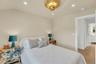 Bedroom featuring light-toned walls, recessed lighting, and a decorative ceiling fixture