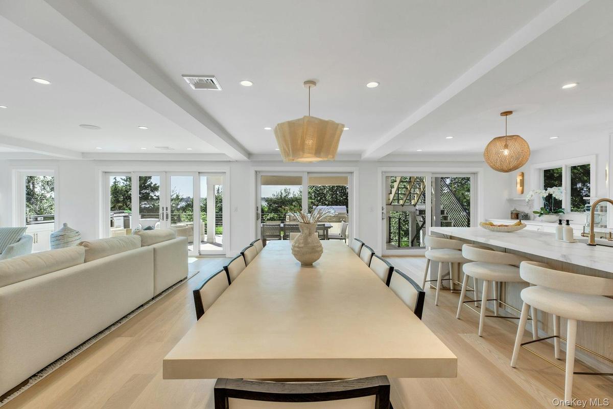 Open concept living space featuring light wood-finish flooring, recessed lighting, and multiple sliding glass doors