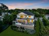 Modern multilevel residence with multiple outdoor decks, a manicured lawn, and mature landscaping