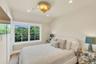 Spacious room featuring a multi-pane window with white trim, wood-finish flooring, a textured wall finish, recessed lighting, and a decorative gold-to