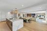 Gourmet kitchen featuring a large island with waterfall countertop, integrated sink, and modern pendant lighting
