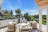 Expansive outdoor deck featuring wood-finish decking and a built-in outdoor kitchen with a sink, integrated grill, and beverage refrigerator
