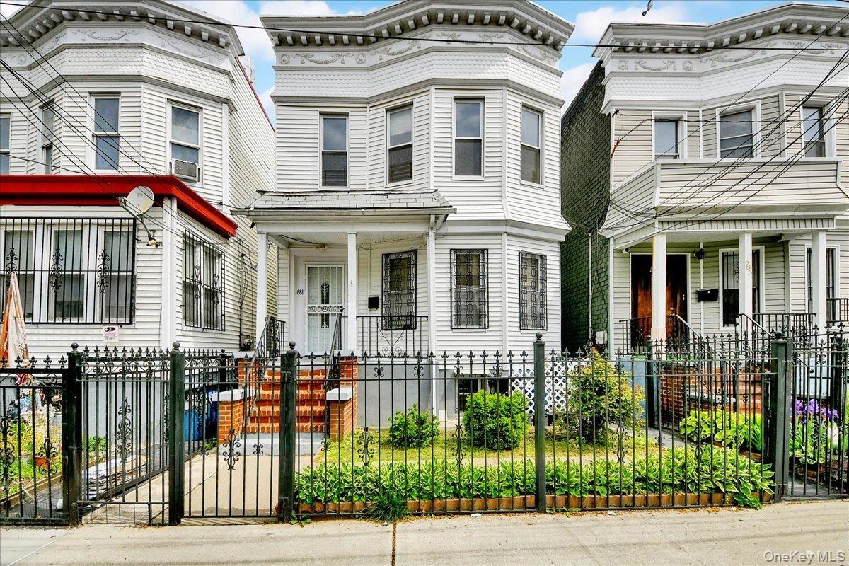 Two-story residence featuring white siding and bay windows on the upper level