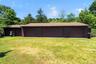 Multi-bay garage structure featuring multiple brown garage doors and a brown shingle roof